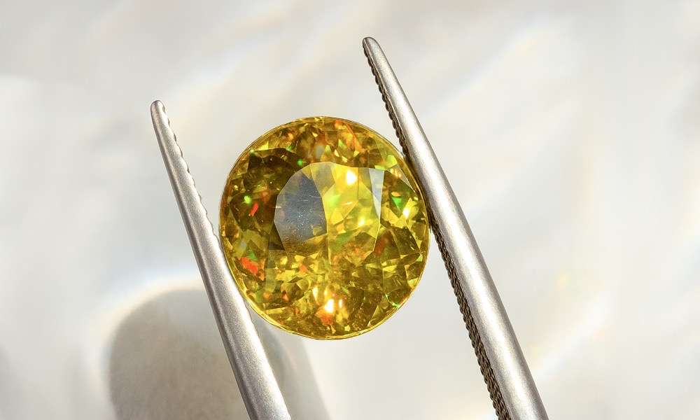 Yellow sphene gemstone showcasing brilliant fire dispersion, exceeding even diamonds by Zinarin