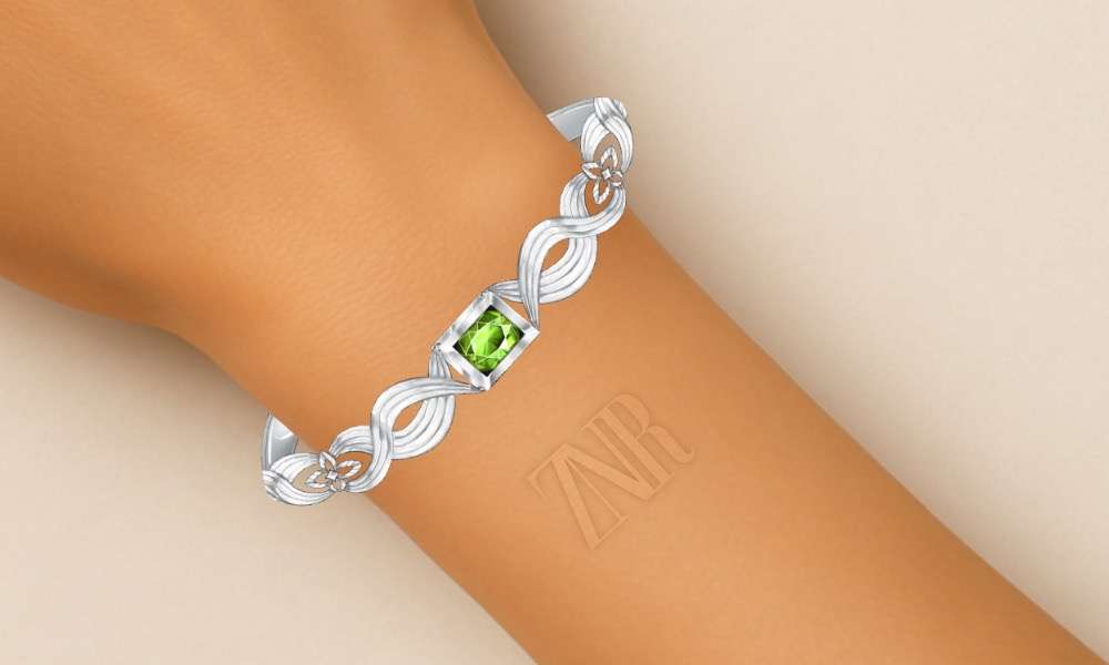 White gold bracelet from the Sukthara Collection featuring a green sphene gemstone, worn on wrist — by Zinarin