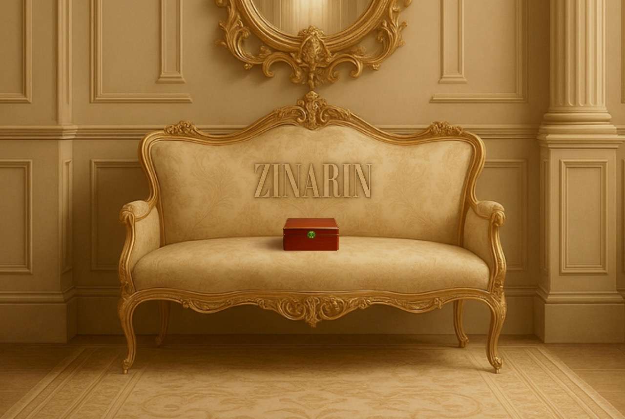 A luxurious vintage sofa with a red jewelry box placed at the center – symbolizing the quiet process of discovering timeless elegance in Zinarin’s creations